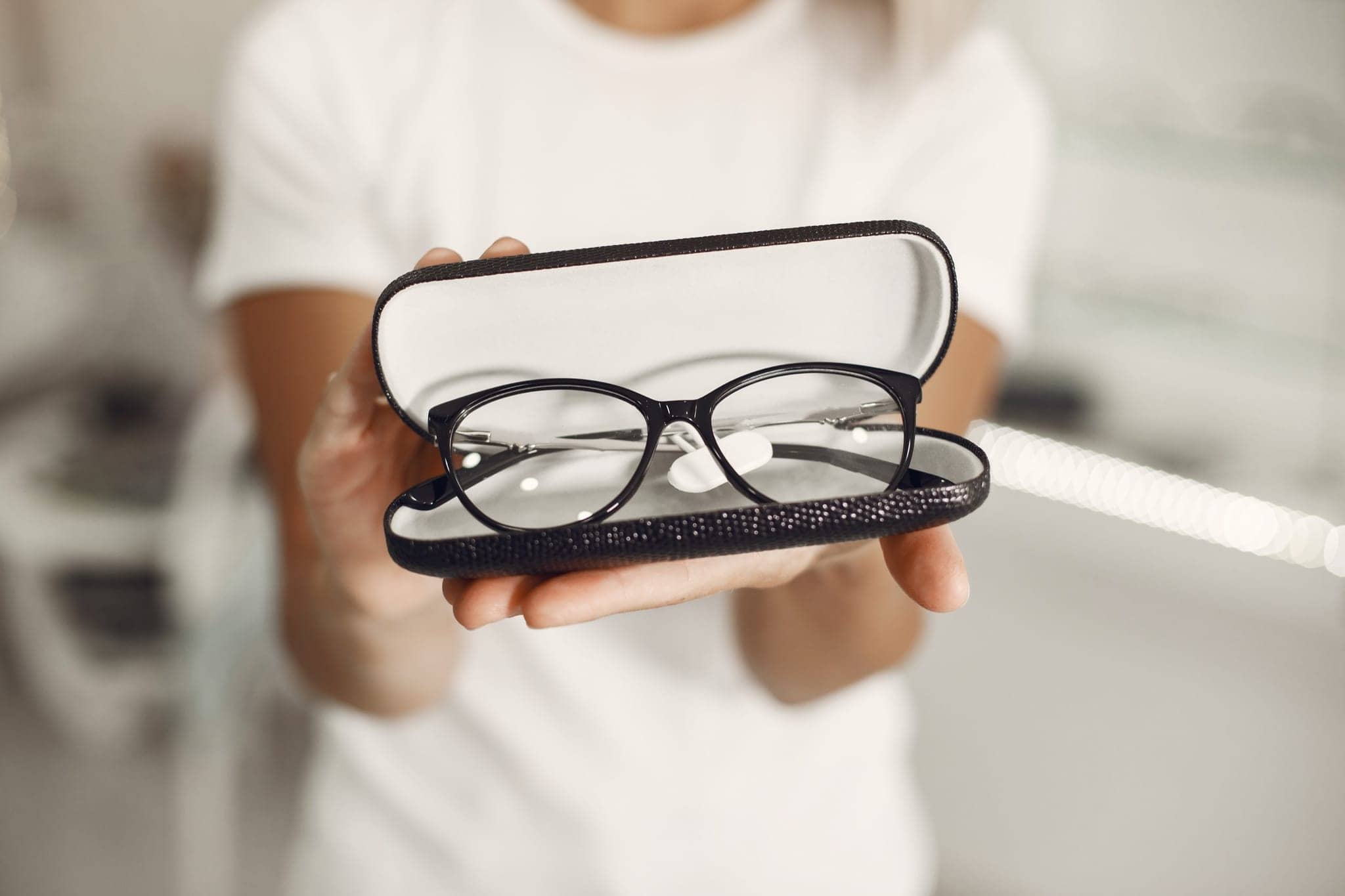 Person presenting eyeglasses in an open case